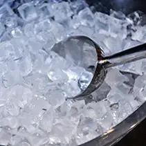 Ice maker scoop in bucket of ice for luxury backyard pool and spa entertainment