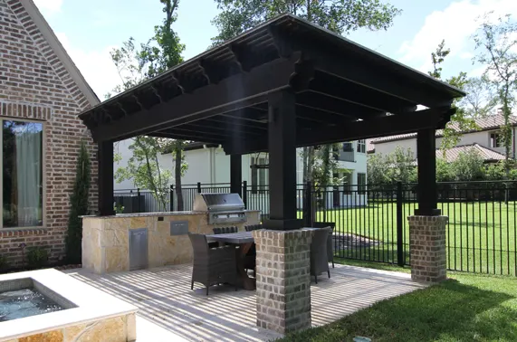 Modern black pergola pavilion with outdoor kitchen and dining area in luxury backyard design