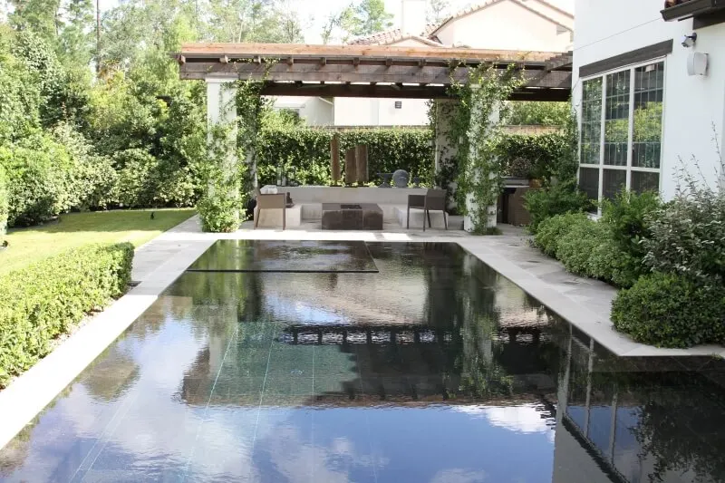 Modern luxury backyard with geometric negative-edge pool, glass tile, spa, and outdoor living patio