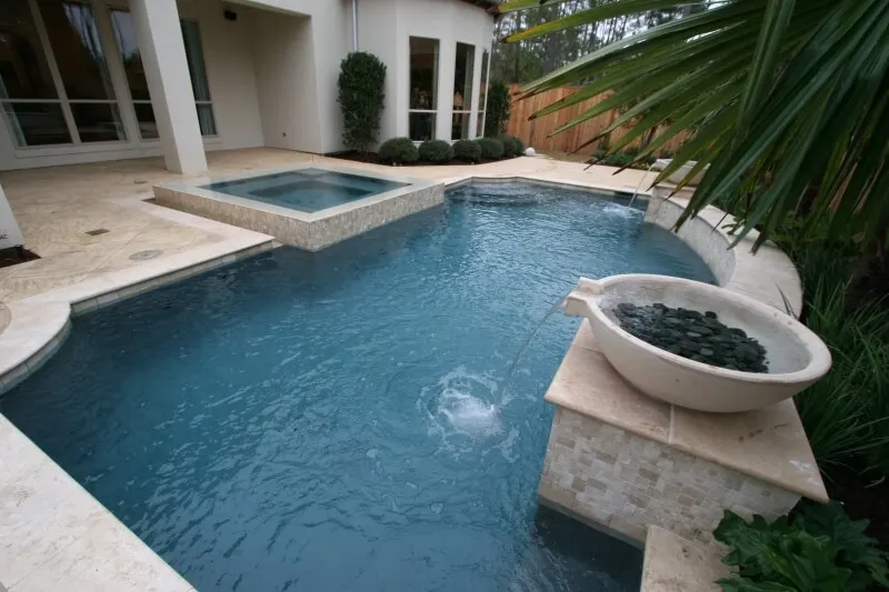 Luxury backyard pool with geometric spa and water feature in custom pool design